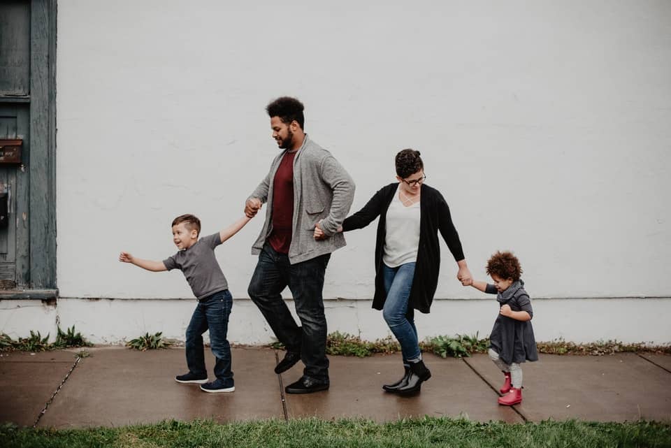 family of four walking on sidewalk